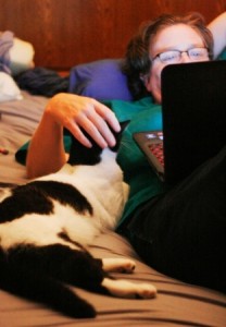 Anita Knowles working on her laptop with her cat, Brenda Lee, helping