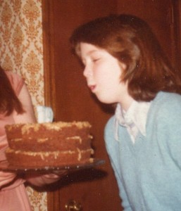 Anita Knowles age 12 blowing out candles on birthday cake